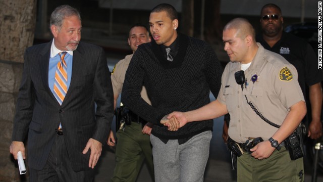 Brown, center, and his attorney Mark Geragos, left, enter the courthouse for Brown's probation progress hearing in Los Angeles on January 28, 2011.