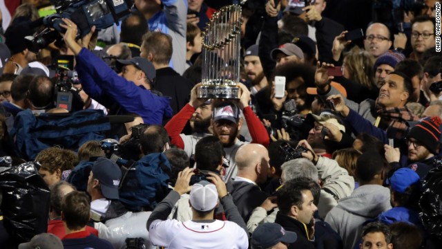 Boston Red Sox players hold up the championship trophy after Game 6 of baseball's World Series against the St. Louis Cardinals on Wednesday, October 30, in Boston. The Red Sox defeated the Cardinals 6-1. 