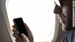 Man Uses Smart Phone Sitting in Airplane Window Seat