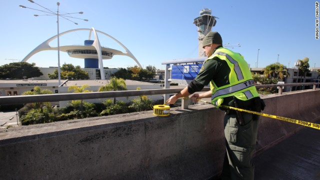 A police officer closes a road at the airport. The area around the airport was jammed with cars Friday morning as police shut down access.