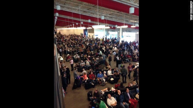 People wait in a terminal after flights were grounded because of the incident.