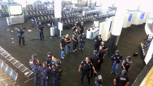 Law enforcement officers gather in Terminal 3 near the scene of the shooting.