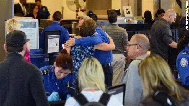 A passenger embraces a TSA screener at Los Angeles International Airport's Terminal 3 after it was reopened on Saturday, November 2. The day before, a gunman opened fire in the terminal, killing a TSA officer. Four other people are recovering from injuries in the shooting.