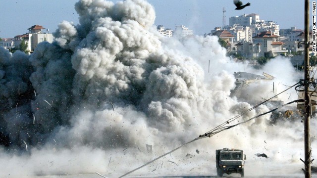 A large explosion rocks Arafat's headquarters in Ramallah moments after Israeli troops blew up a building on September 20, 2002. It was the start of a 10-day siege.