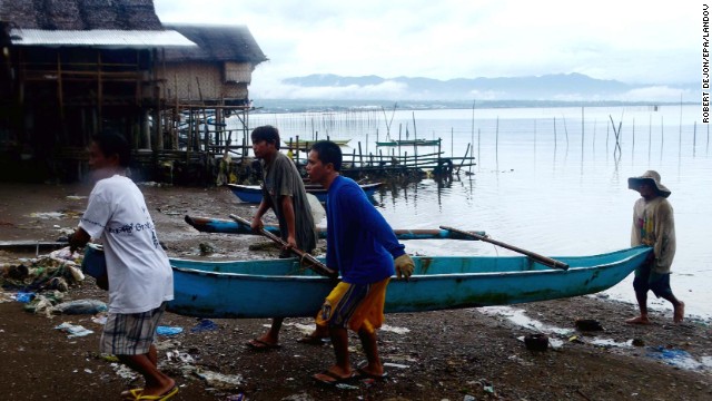 In anticipation of the storm, fishermen carry a boat out of the water in Ormoc, Philippines.