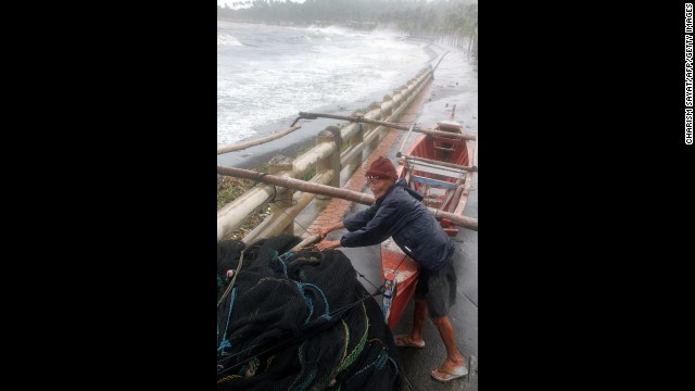 A fisherman secures his wooden boat November 8 as Haiyan's strong winds hit Legazpi.