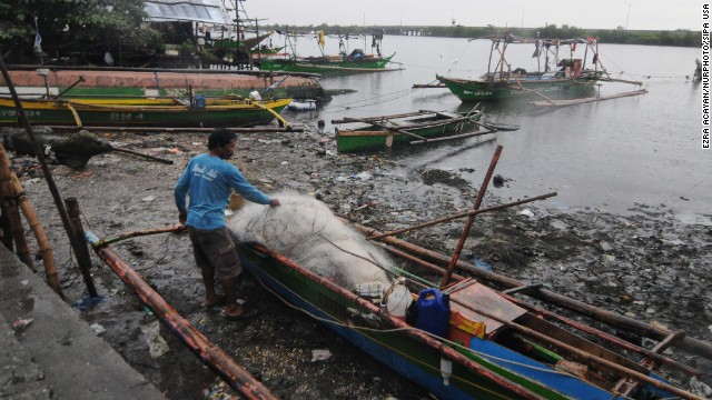 A resident unloads nets off a fishing boat in Bacoor on November 8.