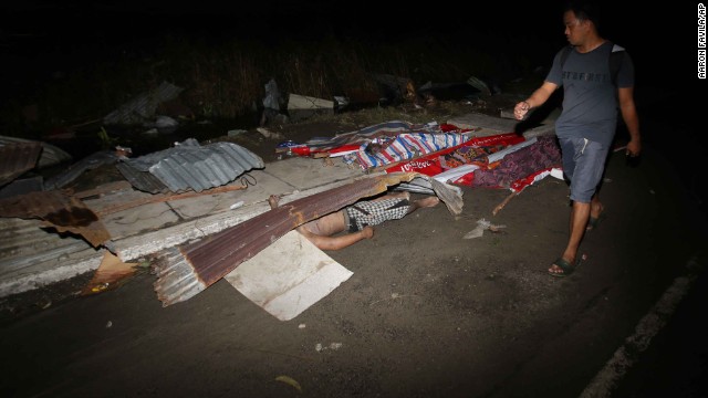 A resident passes victims' bodies on a Tacloban street November 9.