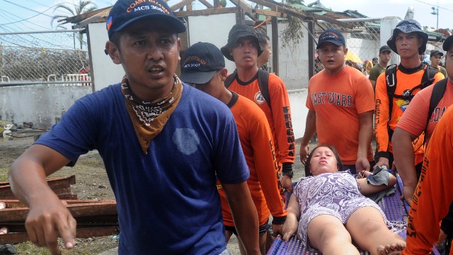 Rescue workers carry a woman about to give birth November 9 at a makeshift medical center at the Tacloban airport.