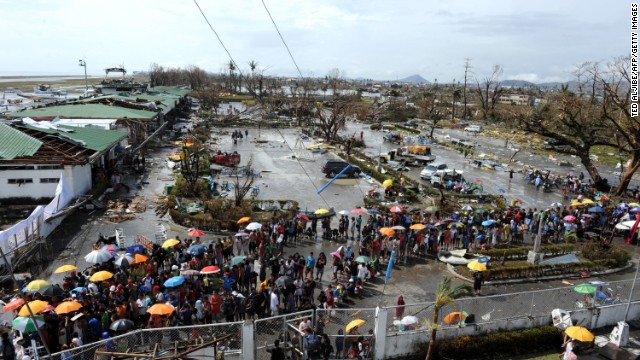 People queue up to receive relief goods being distributed at Tacloban's airport on November 10, 2013.