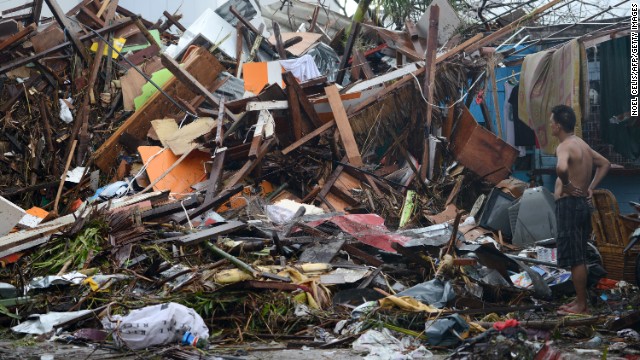 A man looks at the wreckage of destroyed houses in Tacloban on November 10, 2013.