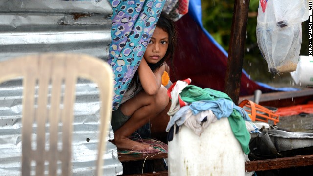 A girl peeks out from a makeshift shelter in Tacloban.