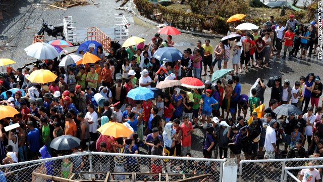 Typhoon survivors wait to receive relief goods at the Tacloban airport on November 10.