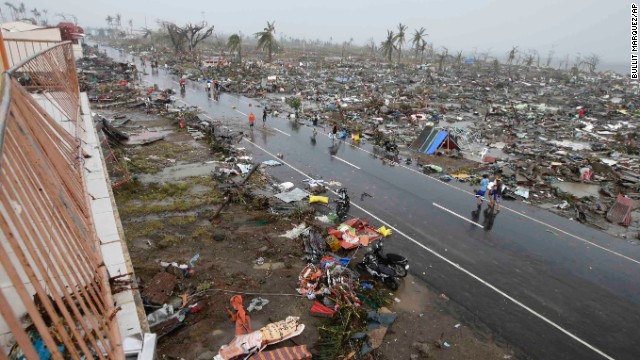 People walk past the Tacloban devastation on November 10.