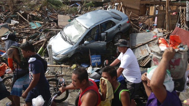 People in Tacloban, Philippines, pass debris on November 11.