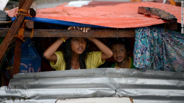 Children peek out from their makeshift shelter in Tacloban on Sunday, November 10.