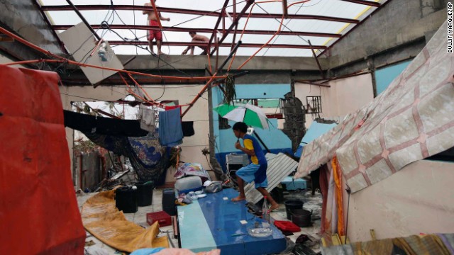 A young Tacloban resident walks inside a damaged home on November 10.