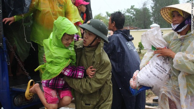 A Vietnamese soldier assists a girl Saturday, November 9, as villagers are moved in the central province of Quang Nam.