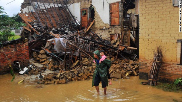 A woman carries a child through a flooded street in Yong'an, China, on November 11. China and Vietnam were also hit hard by the storm.