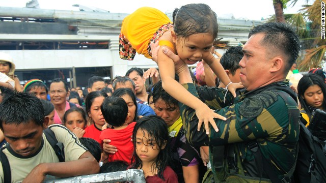 Philippine military personnel try to prioritize children and women first as people wait for evacuation flights November 12 in Tacloban.