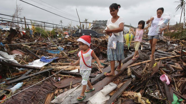 People walk through damage in Tacloban on November 12.