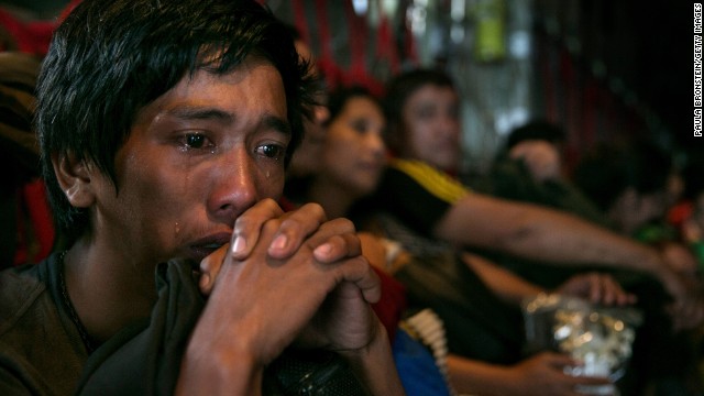 A man sits crying on a packed aircraft in Tacloban on November 12.