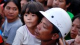 Evacuees wait for their turn to board a military aircraft on November 12, 2013 in Leyte, Philippines.