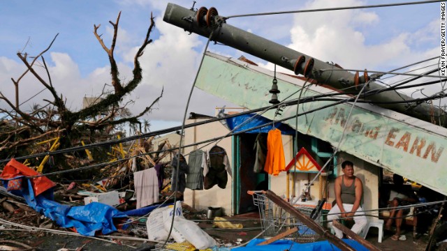 A man sits in front of his destroyed business in Tacloban on November 13. 