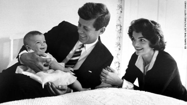 The Kennedy's cuddle daughter Caroline while relaxing on a bed at home on March 25, 1958.