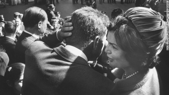 Kennedy, campaigning for president, listens to the whispers of his wife in 1960. 