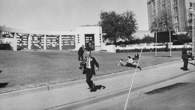 Photographers are seen running shortly after the shooting.