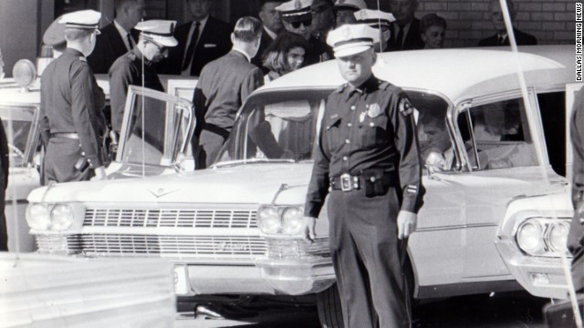 After 2 p.m., Jacqueline Kennedy leaves Parkland Hospital with her slain husband's body. She would ride in the back with the bronze casket. "I had a feeling that if somebody had literally fired a pistol in front of her face that she would just have blinked," said Dallas Police Officer James Jennings, who helped put the casket in the hearse. 