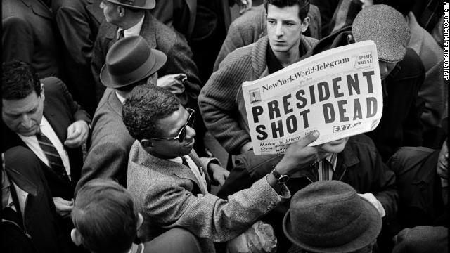 A man holds up a copy of the New York World-Telegram featuring the news of the assassination. Major television and radio networks devote continuous news coverage to the events of the day, canceling all entertainment and all commercials. Many theaters, stores and businesses, including stock exchanges and government offices, are closed.