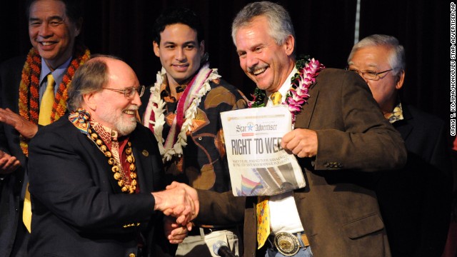 Hawaiian Gov. Neil Abercrombie, left, and former Sen. Avery Chumley hold up a copy of the Star Advertiser after Abercrombie signed a bill legalizing same-sex marriage in Hawaii on Wednesday, November 13, in Honolulu. Hawaii's same-sex marriage debate began in 1990 when two women applied for a marriage license, leading to a court battle and a 1993 state Supreme Court decision that said their rights to equal protection were violated by not letting them marry. Now the island chain is positioning itself for an increase in tourism as visitors arrive to take advantage of the new law, which takes effect December 2. 