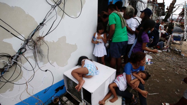 Residents ask for water while waiting to get a free pass to board a US C-130 plane in Tacloban on Tuesday, November 12. 