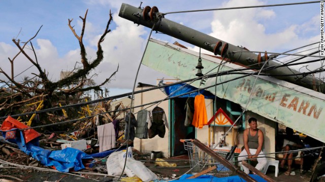 A man sits in front of his destroyed business on November 13 in Tacloban.