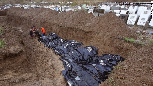 Workers arrange bodies at a mass burial site at a Tacloban cemetery November 14.