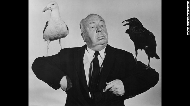 British film director Alfred Hitchcock poses with a seagull and a raven in a promotional still for his film "The Birds." The film was released on March 28, 1963.