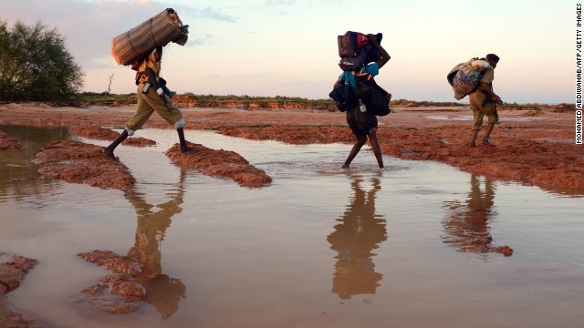 People walk with their belongings in the area around Sinujiif as they evacuate on November 14, 2013 after a ferocious storm and days of heavy floods in Somalia's northeastern Puntland region. Somalia has ranked in the top 10 in Maplecroft's political risk index for the past six years.