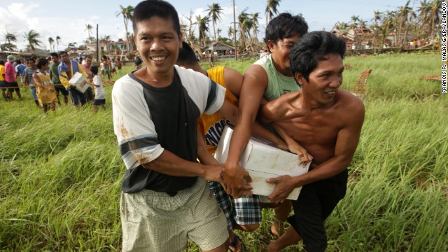 Typhoon victims in Salcedo, Philippines, hold onto a box of relief goods received November 16 from a U.S. Navy helicopter.