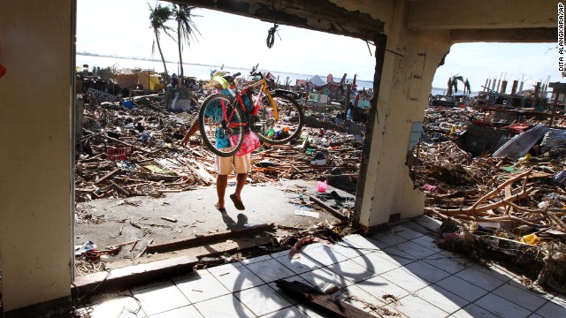 A man carries a bicycle as he walks through the ruin of a building ravaged by the typhoon in Tacloban on November 16.