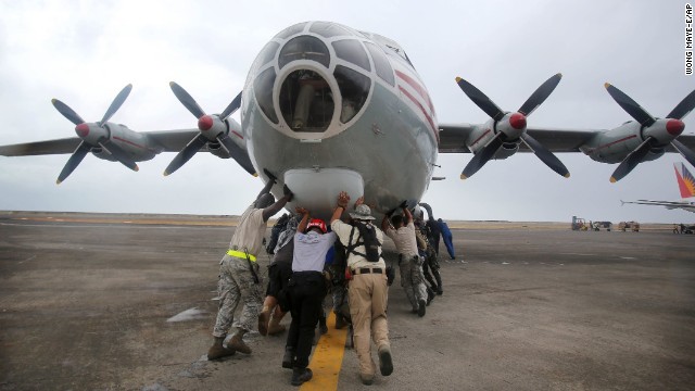 U.S. Navy personnel and other volunteers push a Russian cargo plane off the tarmac to make way for other aircraft November 17 in Tacloban.