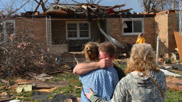 Ray Baughman embraces family shortly after his home was destroyed by a tornado south of Peoria in Pekin, Illinois, on November 17. 