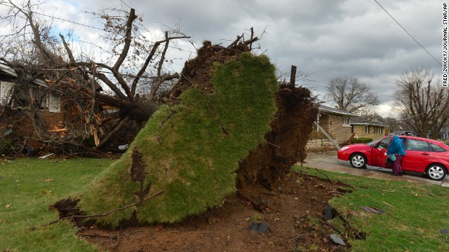 A home is damaged by a tree that was uprooted during the storm in Pekin on November 17. Pekin is part of the cluster of towns in central Illinois hit hard by the severe weather.