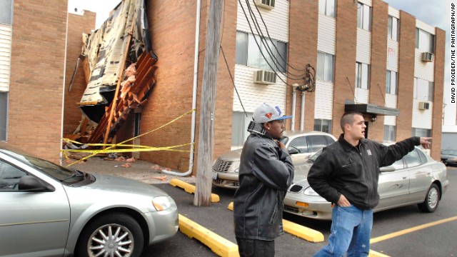 An apartment manager warns Illinois State University students to stay back from a roof that blew off "The U" student apartments in Normal, Illinois, on November 17.