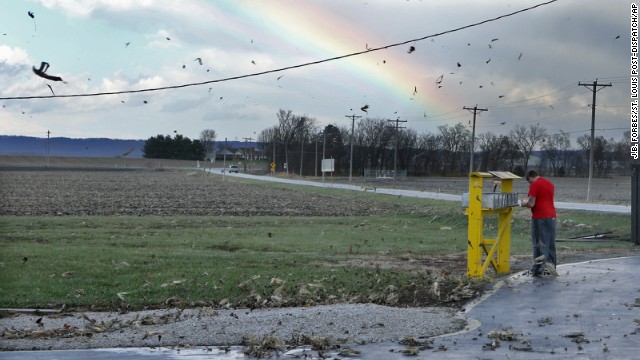 Corn husks fly through the air as Eric Crawford checks his mail after the storm passed in rural Orchard Farm, Missouri, on November 17.