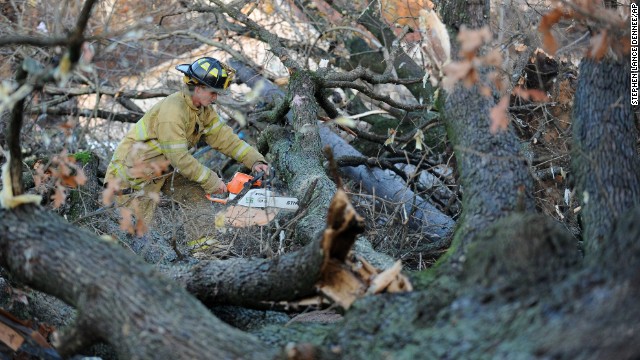 A firefighter works to clear a tree from a street in Brookport, Illinois, on November 17.