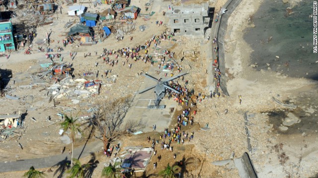 People gather around a helicopter as it delivers relief supplies November 17 in Guiuan, Philippines.