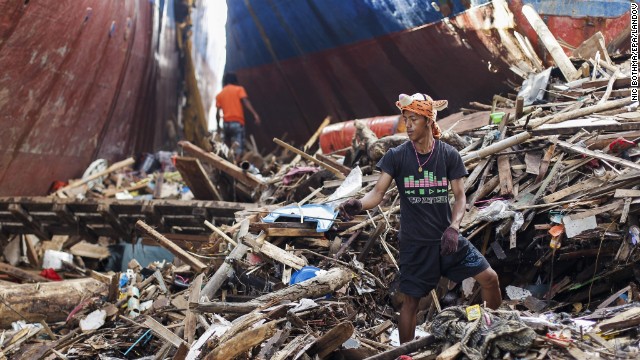 Survivors salvage wood next to stranded ships in Tacloban on November 19.