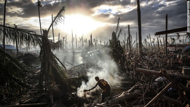 A man fans the flames of a fire in Tanauan, Philippines, on November 19.